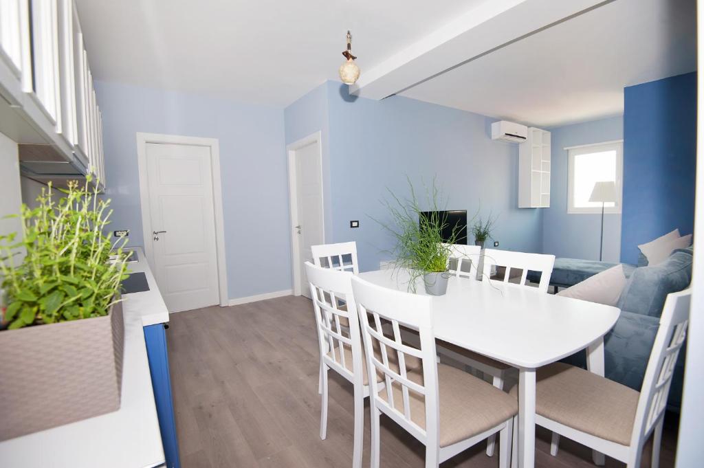 een eetkamer en een woonkamer met een witte tafel en stoelen bij Dion Apartment in Tirana