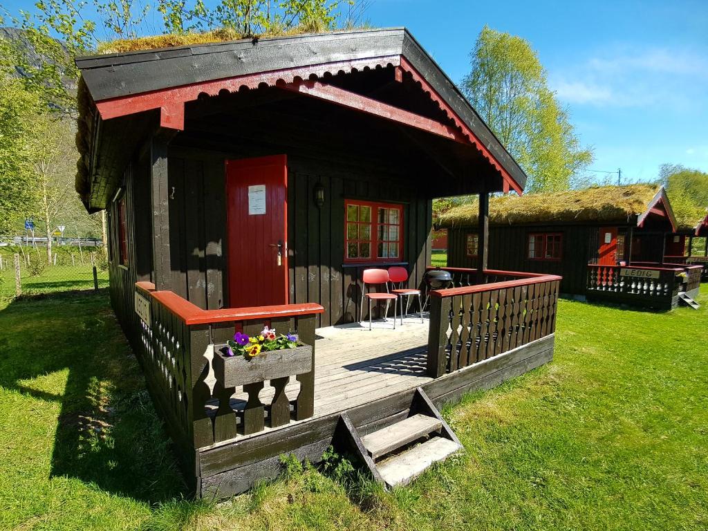 a small cabin with a deck in the grass at Vistdal Camping in Myklebostad