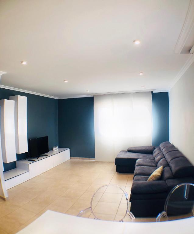 a living room with a couch and a flat screen tv at the Beach House in A Pobra do Caramiñal