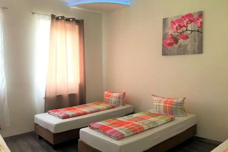 2 łóżka pojedyncze w pokoju z oknem w obiekcie Hostel "Berkut" w Norymberdze