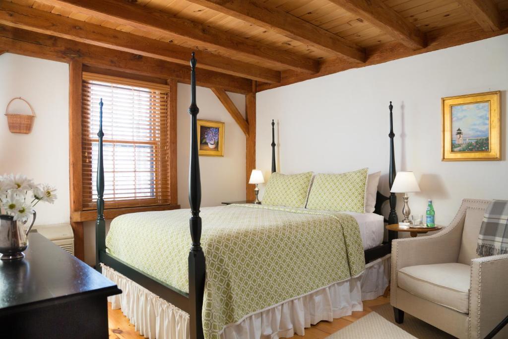 a bedroom with a bed and a chair at Seven Sea Street Inn in Nantucket