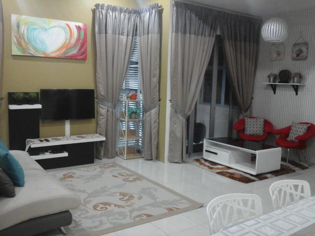 een woonkamer met een bank en een tv bij Miker Homestay in Seri Iskandar