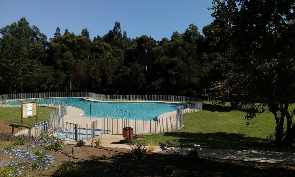 ein Schwimmbad mit einem Zaun um ihn herum in der Unterkunft Lomas 3 Bosque y Playa in Papudo
