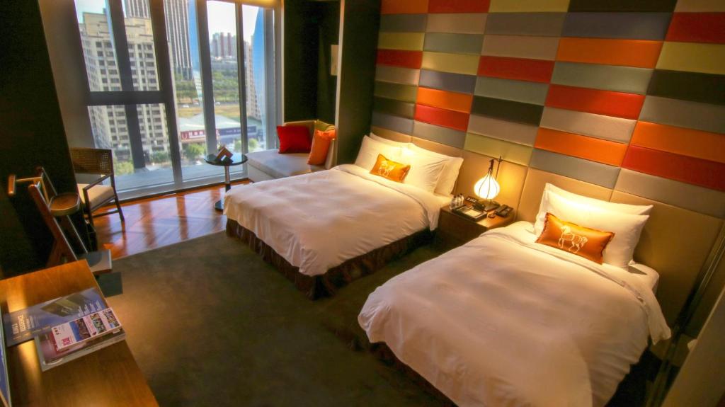 a hotel room with two beds and a colorful wall at H2O HOTEL in Kaohsiung