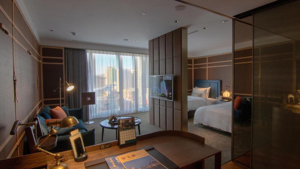 a hotel room with a bedroom with a bed and a desk at H2O HOTEL in Kaohsiung