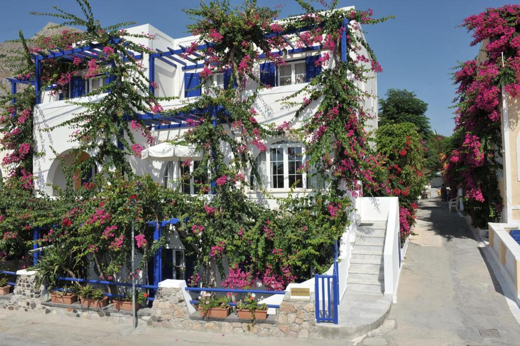 a white building with lots of flowers on it at Proteas Hotel in Kamari