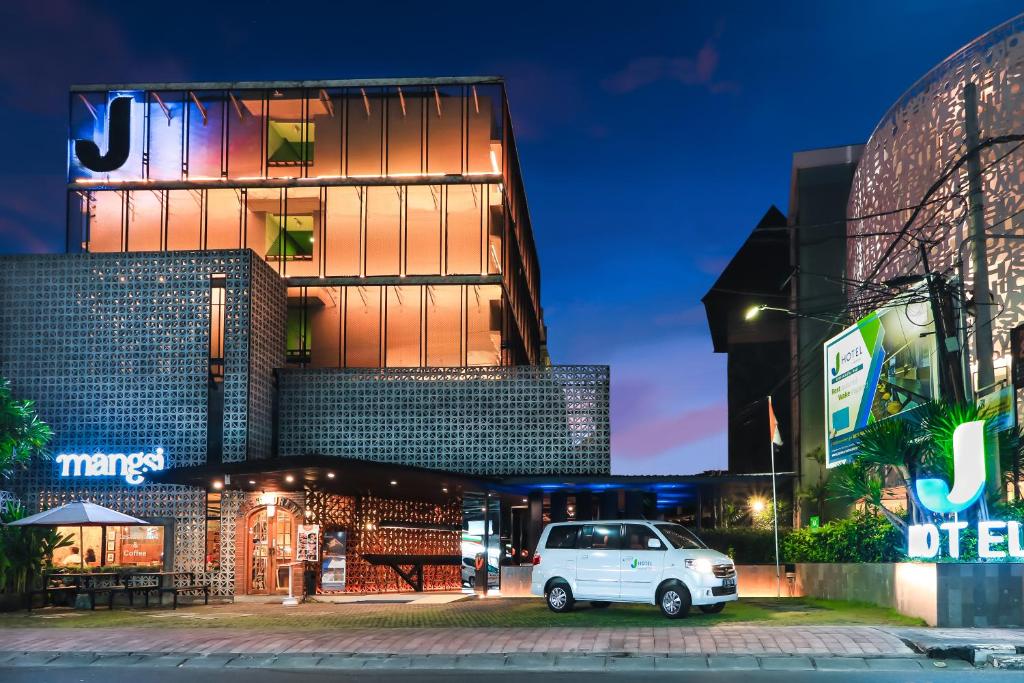 a white van parked in front of a building at night at J Hotel Kuta in Kuta