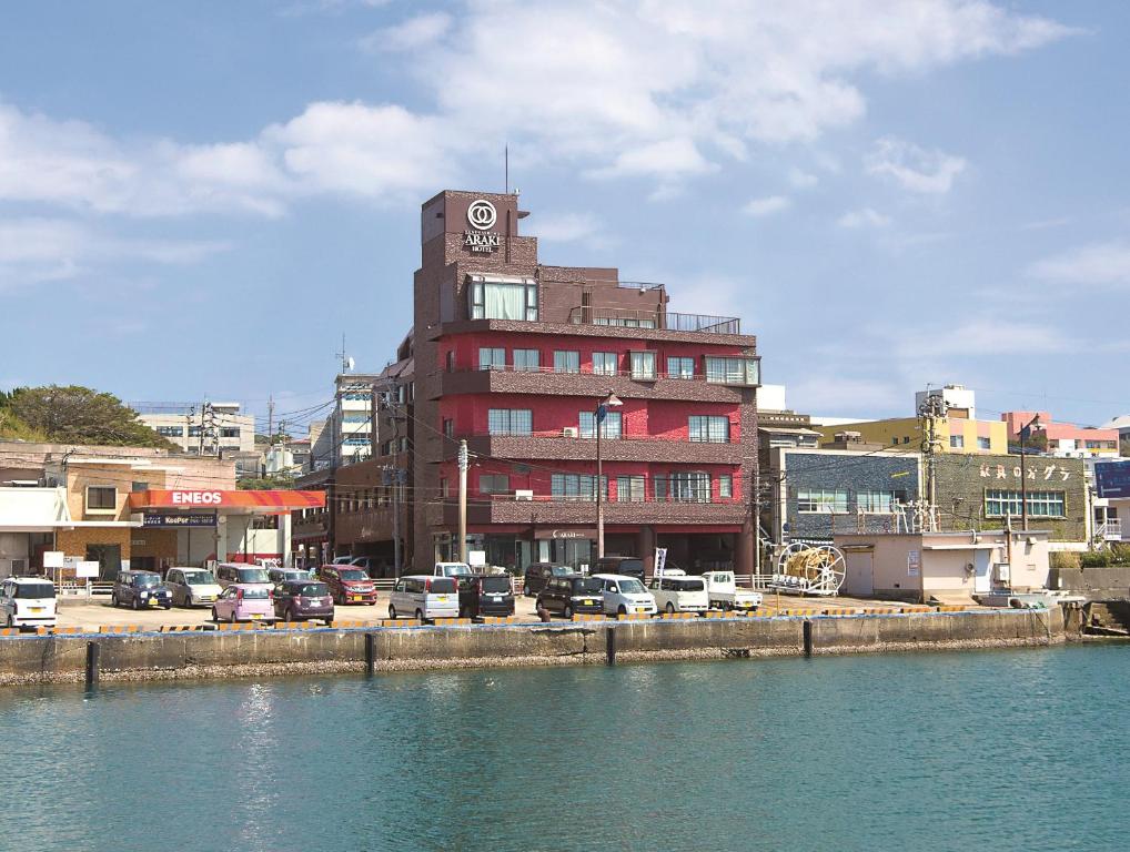 un edificio con una torre de reloj junto a un cuerpo de agua en Tanegashima Araki Hotel, en Nishinoomote