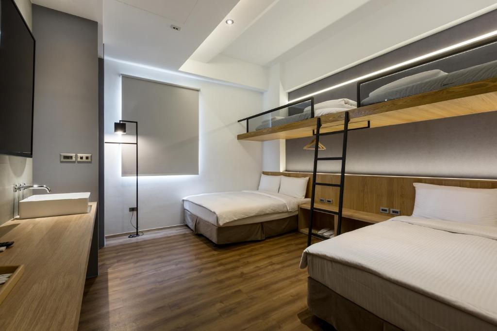 a bedroom with two bunk beds and a bathroom at Green Hotel in Magong