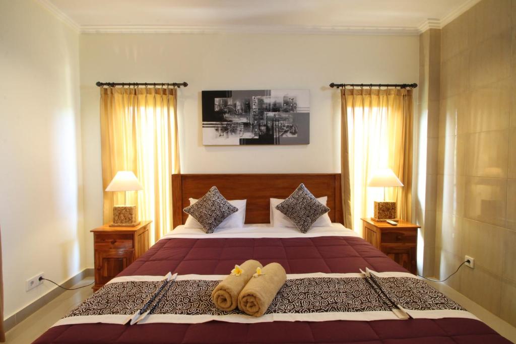 una camera da letto con un letto e due asciugamani di Jempiring Homestay ad Ubud