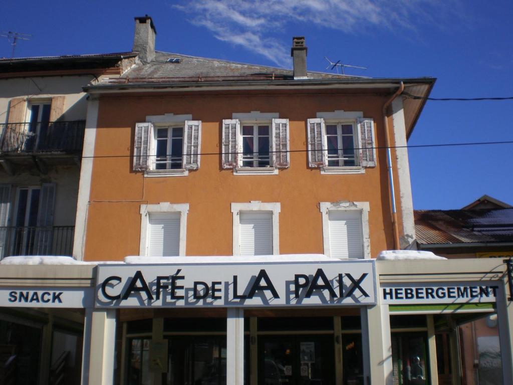 un bâtiment avec un panneau indiquant le parc caffe bella dans l'établissement Appart Hotel de la Paix, à Barcelonnette