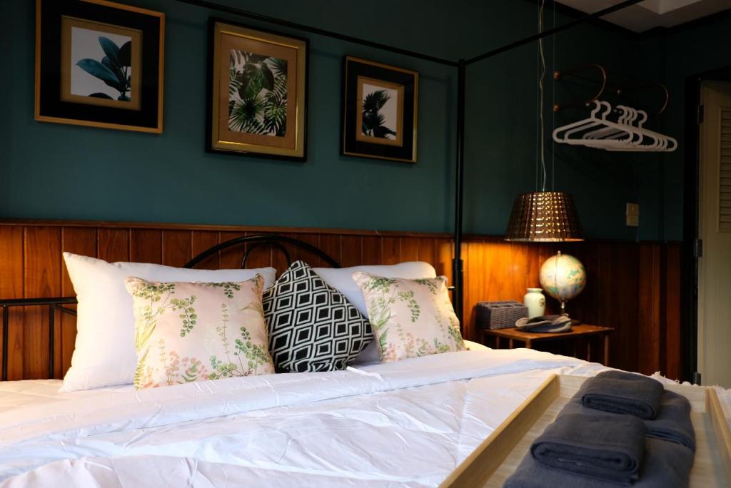 ein Schlafzimmer mit einem weißen Bett mit grünen Wänden in der Unterkunft TANA CASA 12 Large Sathorn 6BR Townhome with Parking in Bangkok