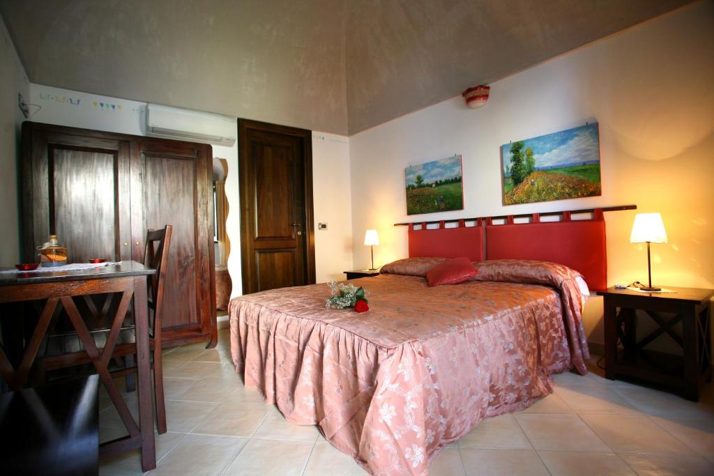 a bedroom with a bed and a table and a desk at L'Eco dell'800 in Furore