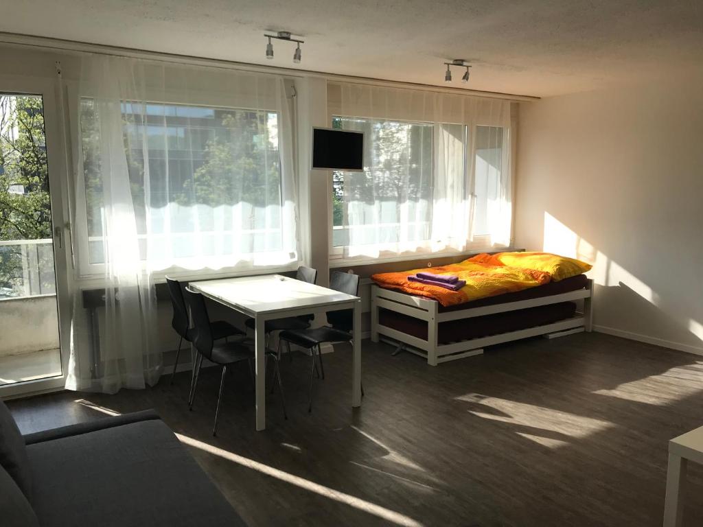 um quarto com uma cama, uma secretária e uma mesa em Anstatthotel Zug - self-check-in em Zug