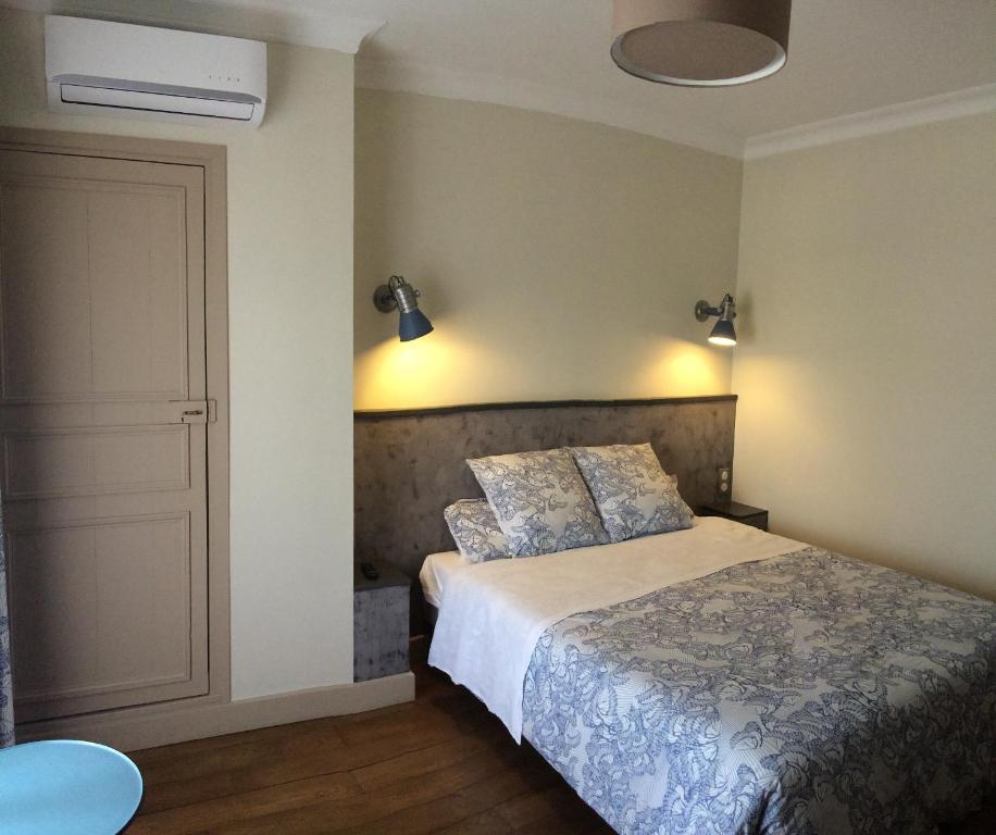 a bedroom with a bed and a door and lights at Demeure des Pothières in Villeneuve-la-Lionne