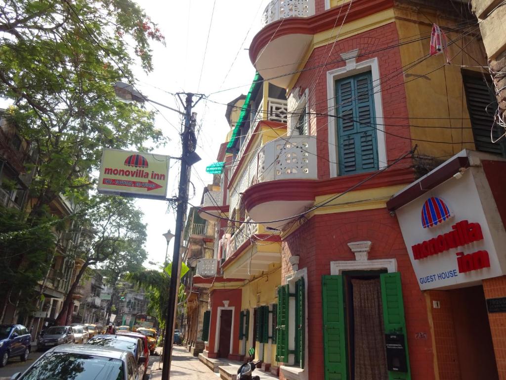 un edificio con un letrero al lado de una calle en Monovilla Inn en Calcuta
