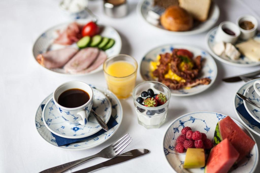 una mesa con platos de comida y una taza de café en Hotel Inger en Hulsig