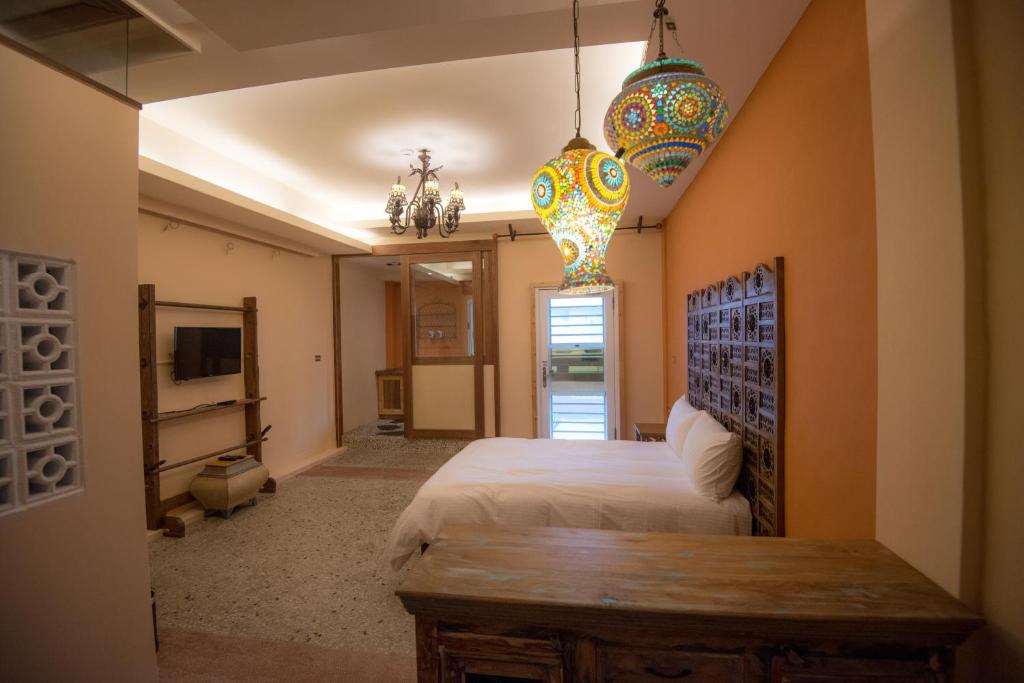 a bedroom with a bed and two chandeliers at Ripoll'es Homestay in Chishang
