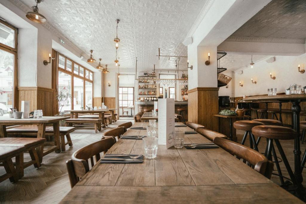 a dining room with wooden tables and chairs at Langley Hotel Gustavia in Chamonix