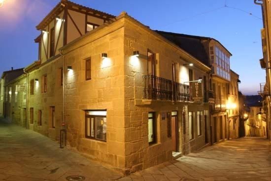 ein Backsteingebäude mit einem Balkon an der Seite in der Unterkunft Hotel O Portelo Rural in Allariz