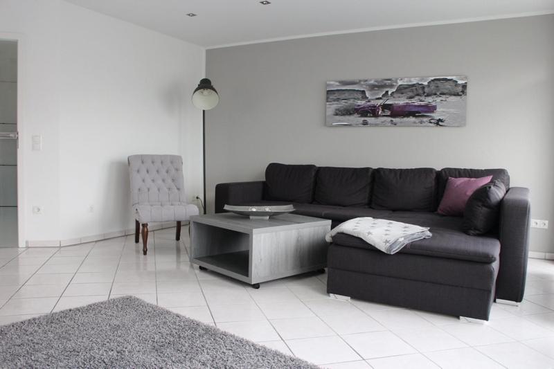 a living room with a black couch and a table at FeWo-Nordwalde in Nordwalde