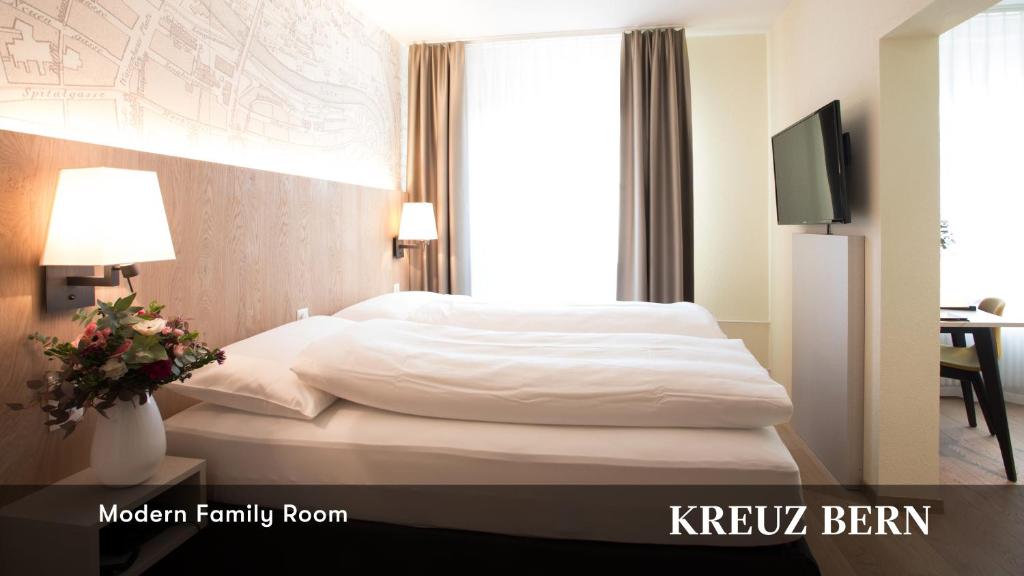 a hotel room with a bed and a window at Kreuz Bern Modern City Hotel in Bern
