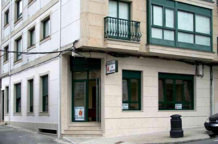 un edificio en la esquina de una calle de la ciudad en Albergue Los Caminantes 2 en Arzúa