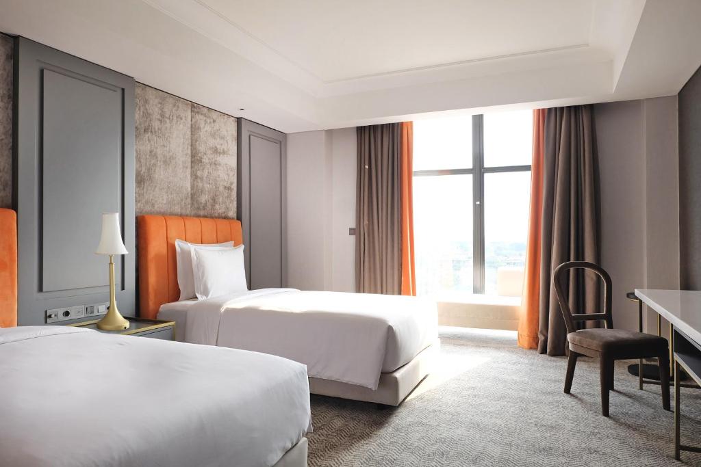Postel nebo postele na pokoji v ubytování Goodrich Suites, Jakarta