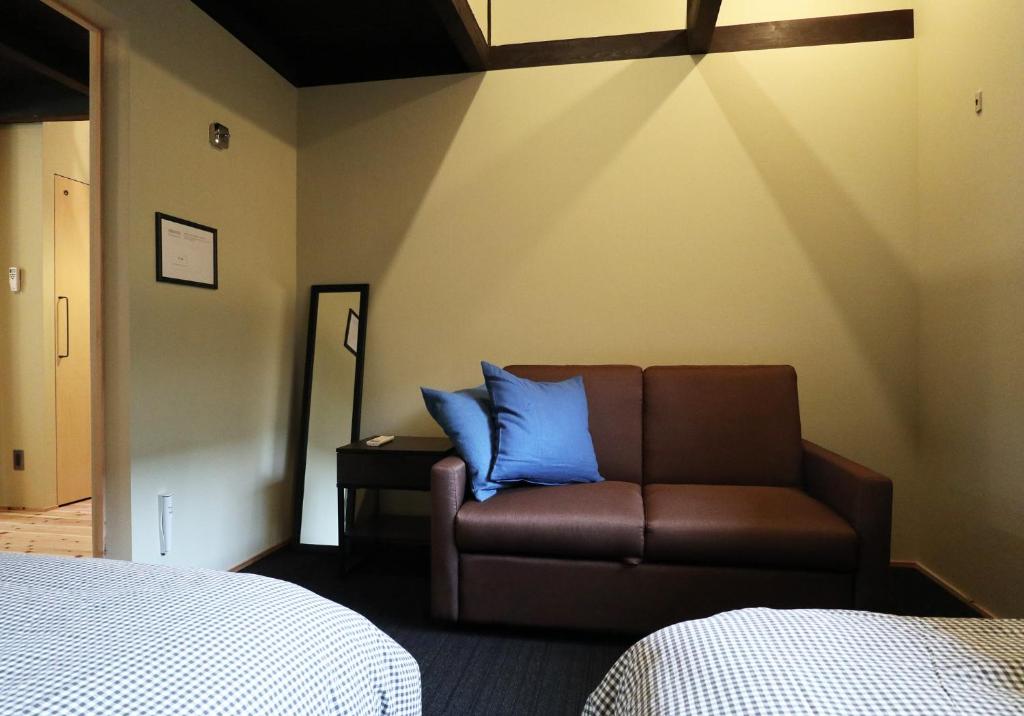 a bedroom with a couch and blue pillows at ORI stay and living in Kyoto