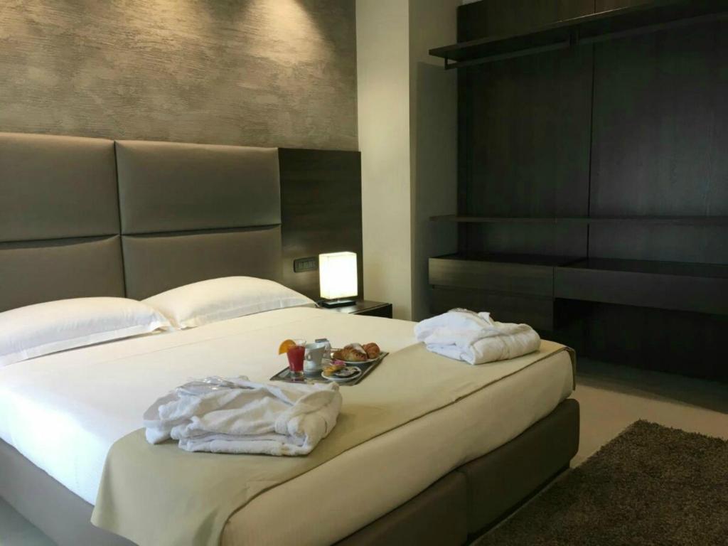 una camera da letto con un letto con due asciugamani sopra di Plus Welcome Milano a Milano