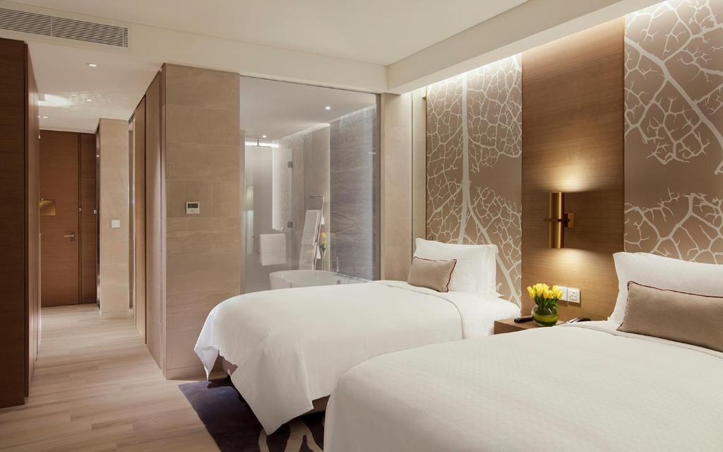a hotel room with two beds and a bathroom at Al Bandar Rotana – Dubai Creek in Dubai