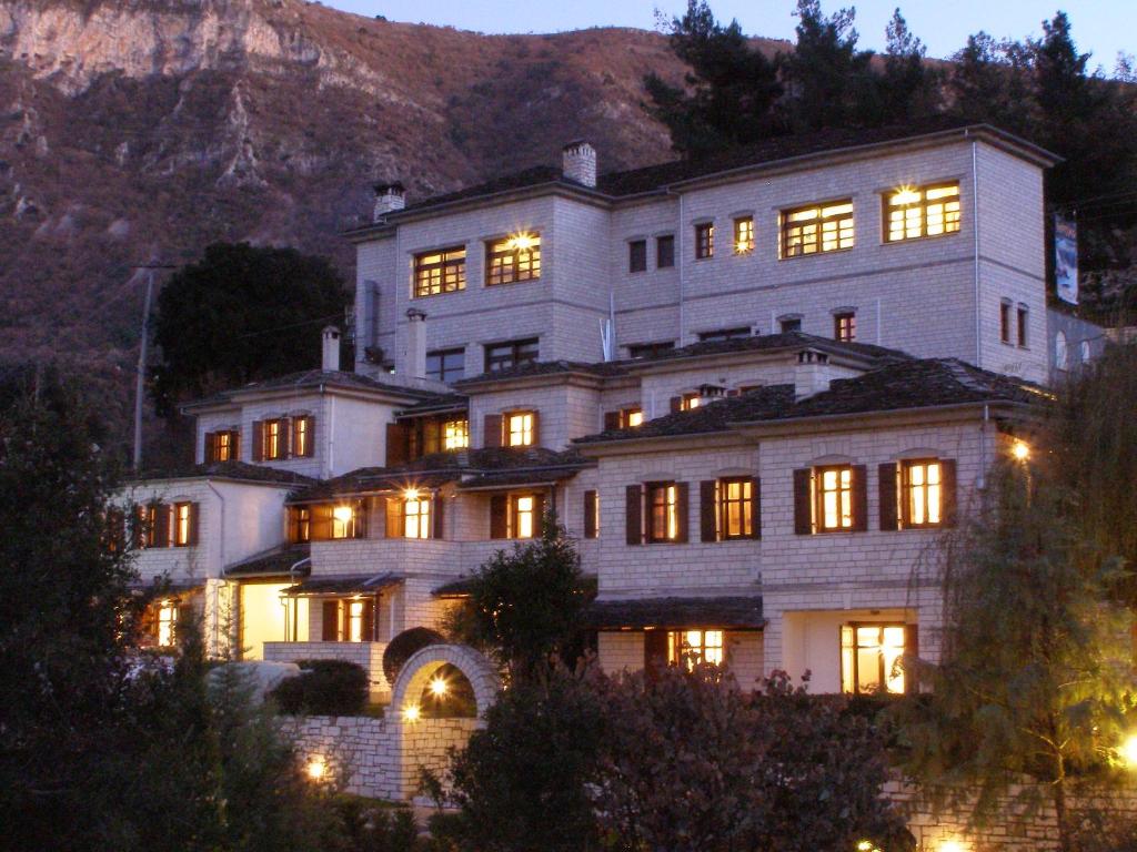 a large white building with many windows at night at Hotel Taxiarches in Aristi