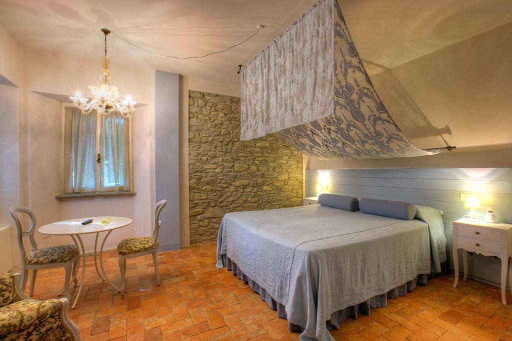 a bedroom with a bed and a table and chairs at Corte San Ruffillo Country Resort in Dovadola