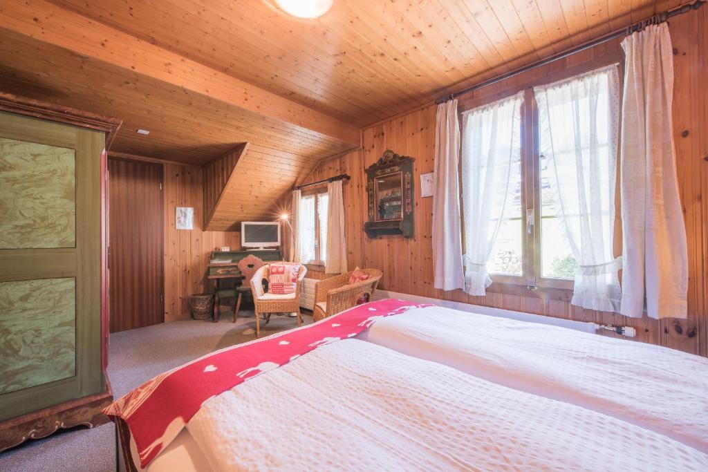 a bedroom with a large bed in a wooden room at Hotel Fassbind Beausite in Beatenberg