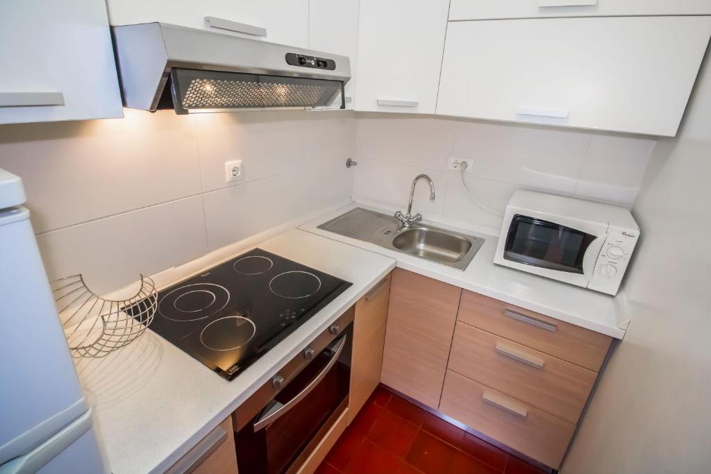 a small kitchen with a stove and a microwave at Pineta House Vidos in Poreč