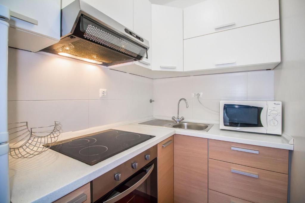 a small kitchen with a sink and a microwave at Pineta House Vidos in Poreč