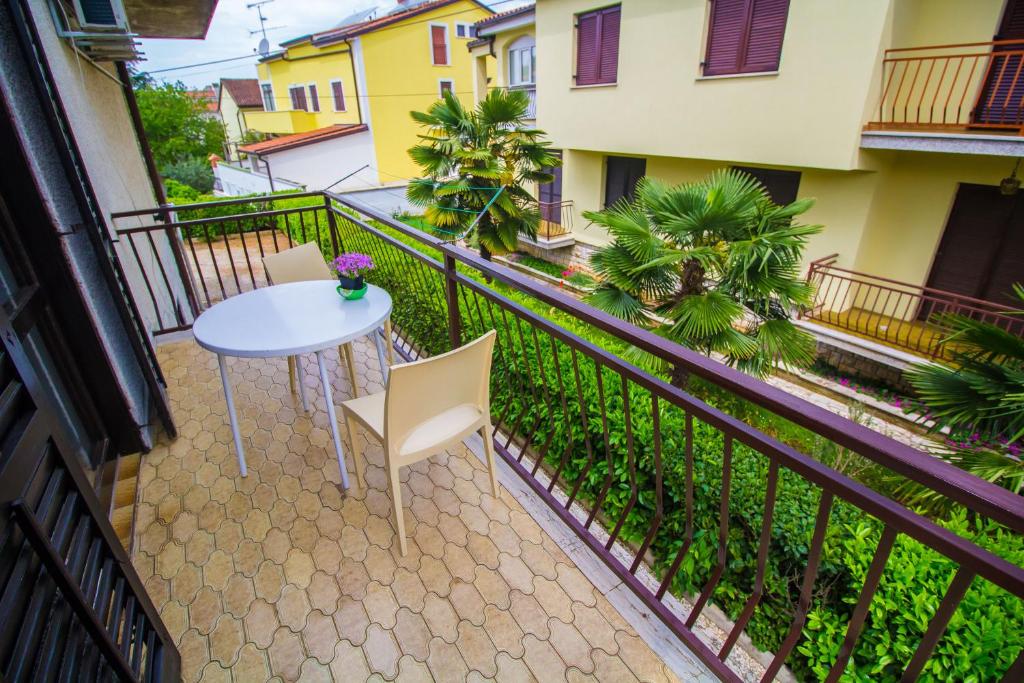 a balcony with a white table and chairs at Pineta House Vidos in Poreč