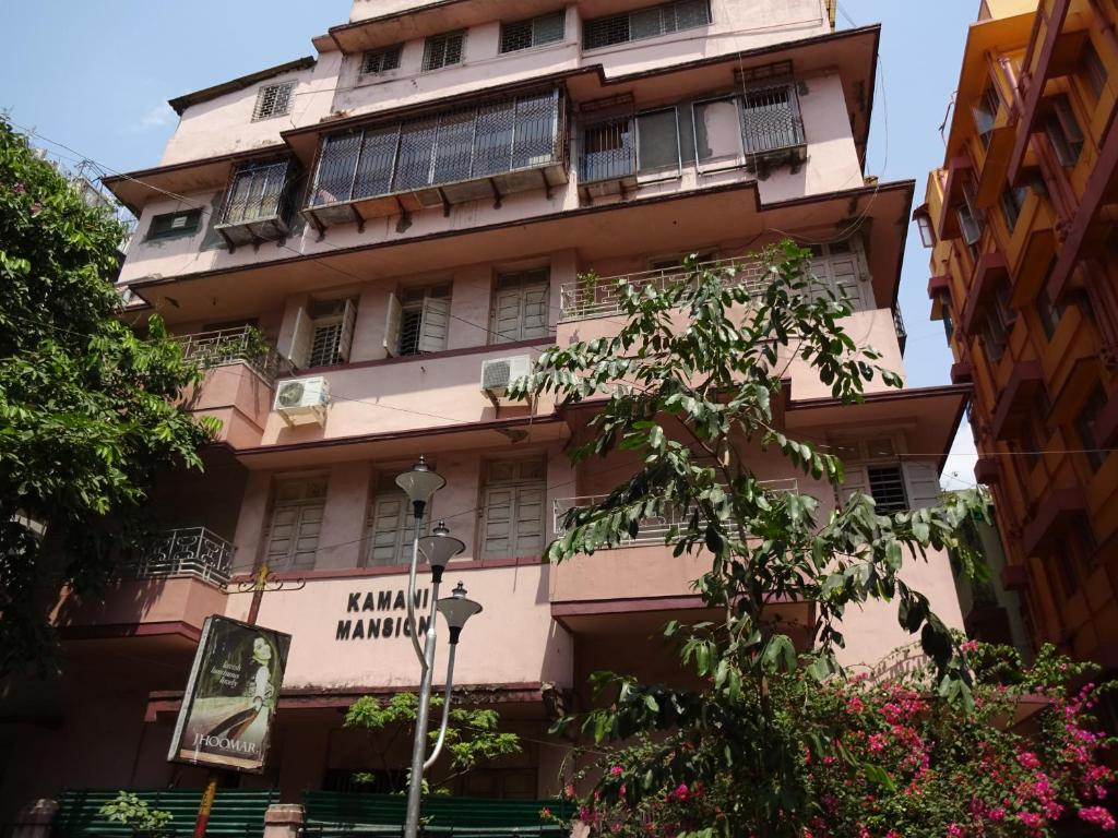 un edificio rosa alto con un cartel. en The Kei Suites, en Calcuta