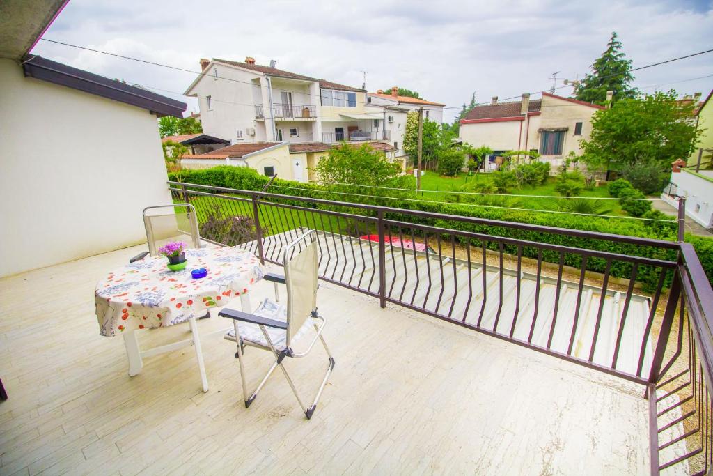 a balcony with a table and chairs on a balcony at Pineta House Vidos in Poreč