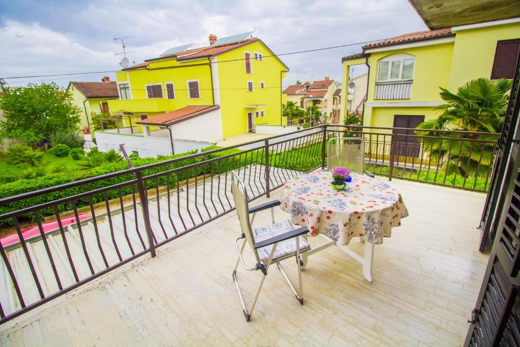a balcony with a table and chairs on a balcony at Pineta House Vidos in Poreč