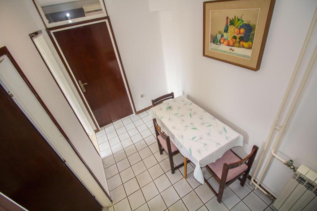 a small table and chairs in a room with a painting at Pineta House Vidos in Poreč