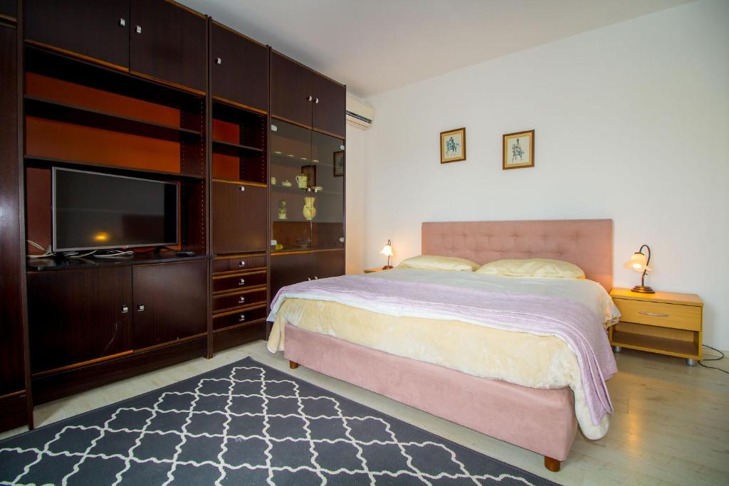 a bedroom with a large bed and a flat screen tv at Pineta House Vidos in Poreč
