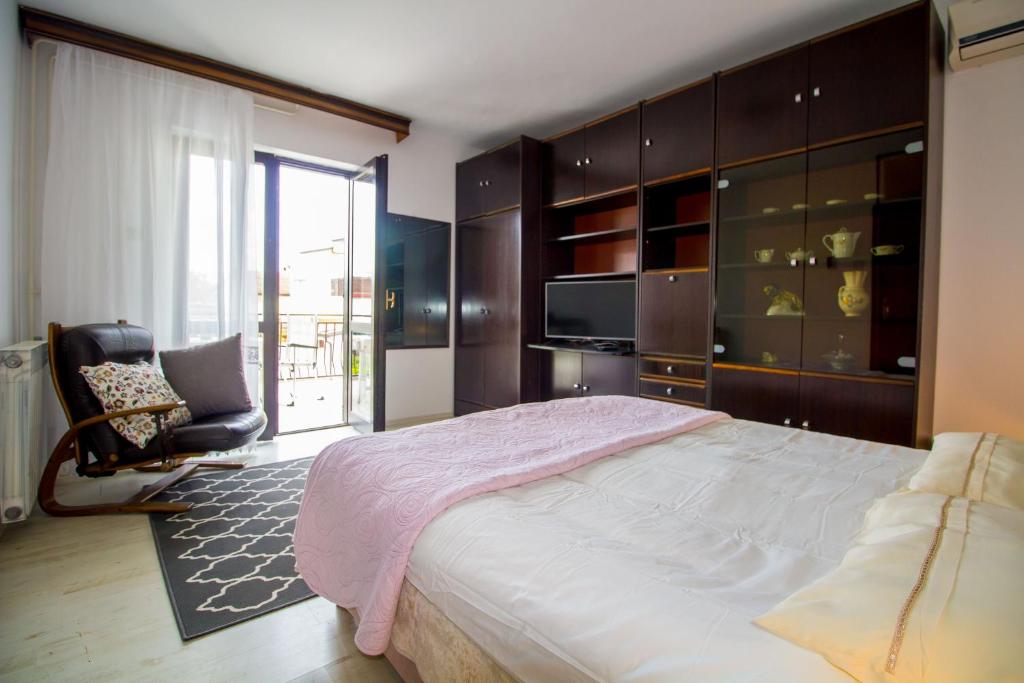 a bedroom with a bed and a chair and a television at Pineta House Vidos in Poreč