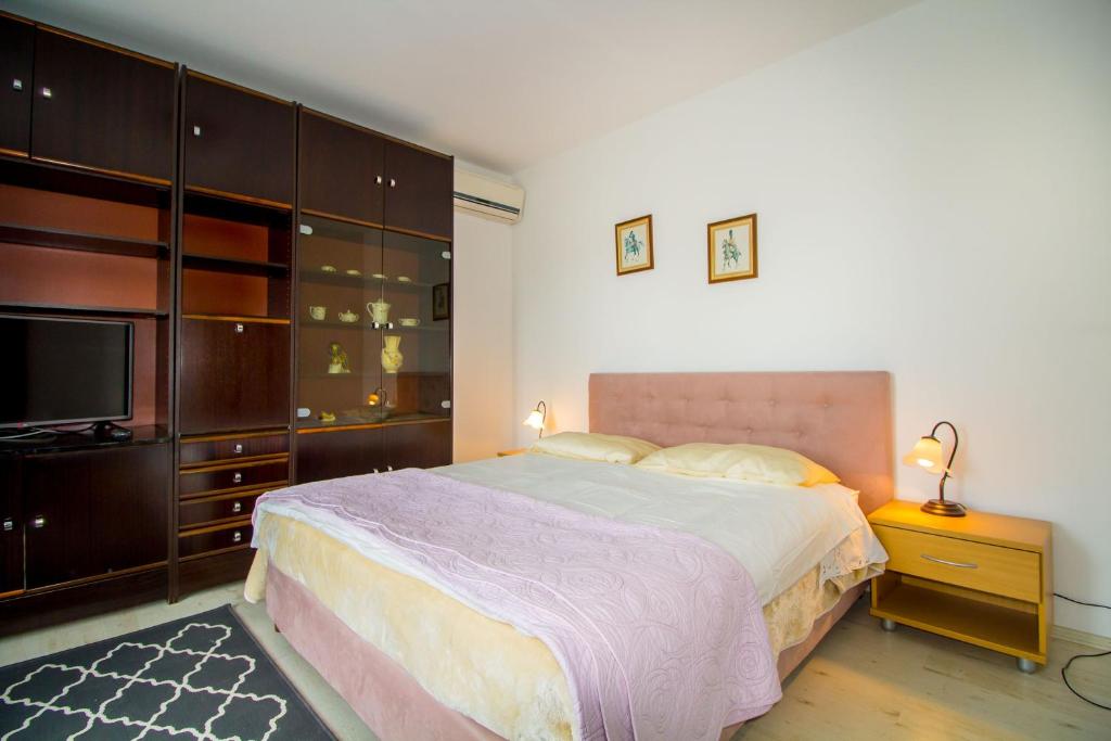 a bedroom with a large bed and a television at Pineta House Vidos in Poreč