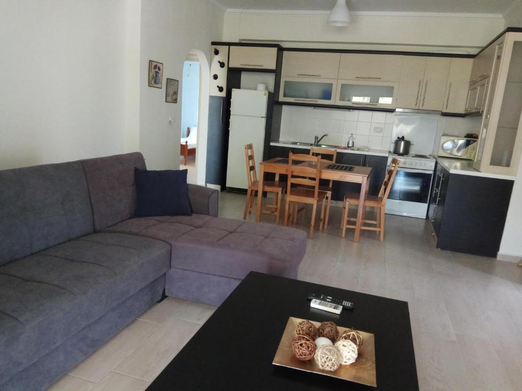 sala de estar con sofá, mesa y cocina en Achilles Apartments, en Sarandë