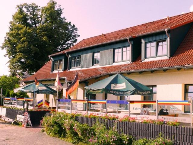 a building with tables and umbrellas in front of it at Landgasthof "Wirtshaus Zur Eibe" in Jabel