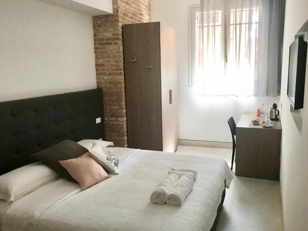 a bedroom with a bed with two towels on it at Al Pozzo di Luce Venezia Suites in Venice