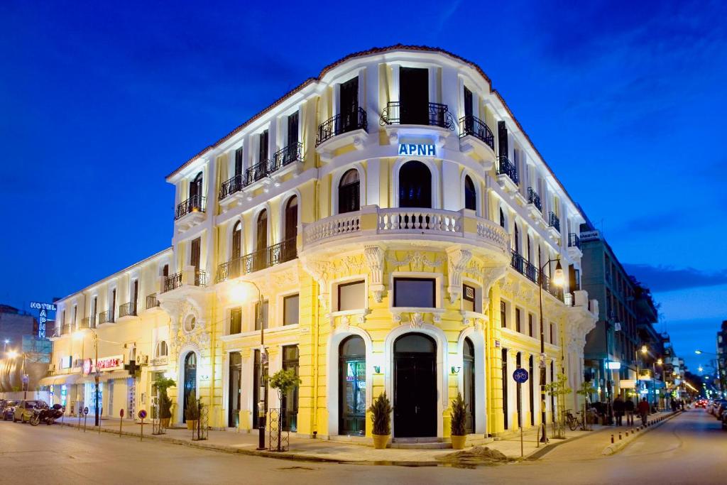 a large white building on a street at night at Arni Hotel Domotel in Karditsa