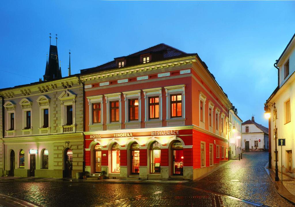 un edificio rojo al lado de una calle en Hotel Merlot, en Louny