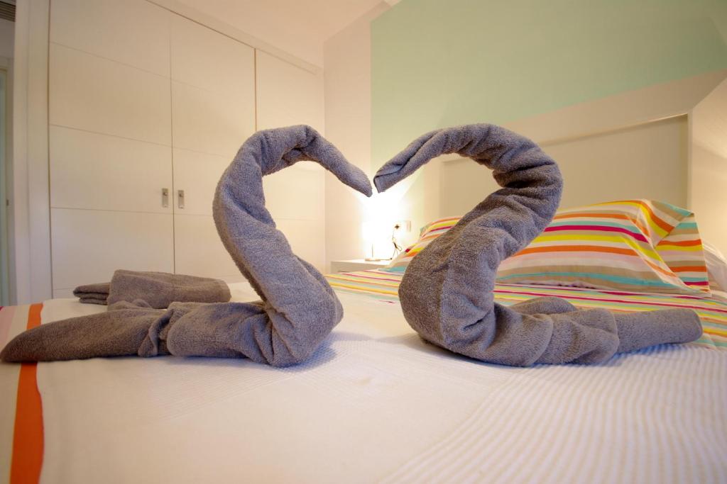 une paire de serviettes en forme de cœur assise sur un lit dans l'établissement Livingtarifa Sol Tarifa, à Tarifa